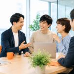 明るいオフィスで社長と若手社員が笑顔で話し合い、リファラル採用による人材紹介と職場の信頼関係をイメージさせる様子