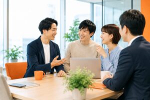 明るいオフィスで社長と若手社員が笑顔で話し合い、リファラル採用による人材紹介と職場の信頼関係をイメージさせる様子